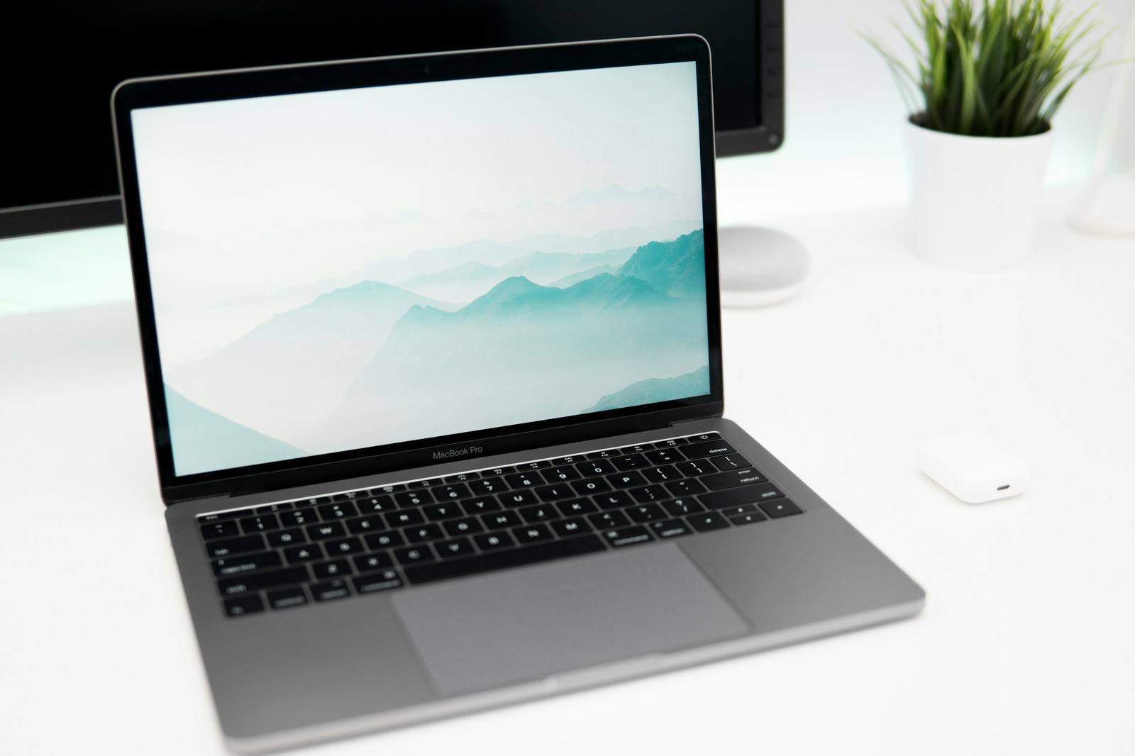 A MacBook open on a white desk